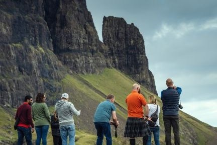 A Hairy Coo tour group taking photos of the mountains in the Isle of Skye