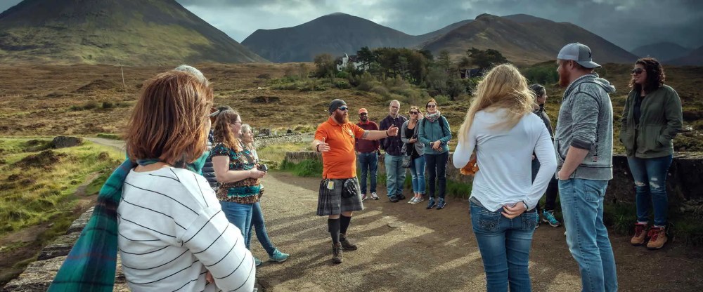 A Hairy Coo tour guide talking to his visitors at Sligachan, Isle of Skye