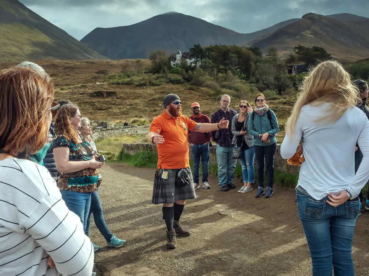 A Hairy Coo tour guide talking to his visitors at Sligachan, Isle of Skye