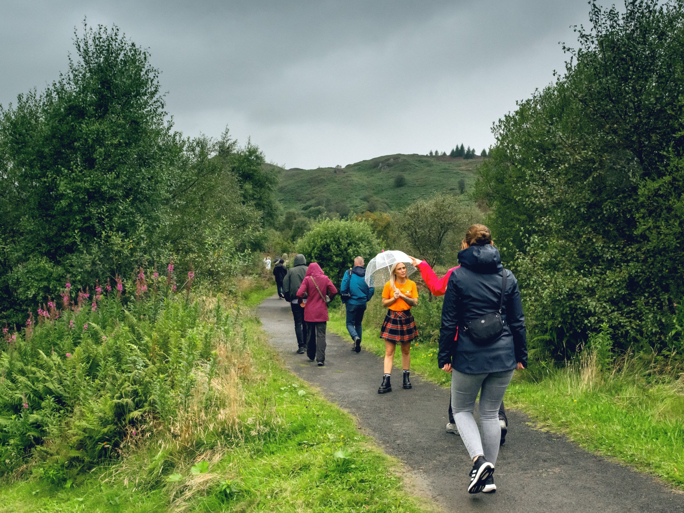 Hairy Coo tour visitors on a country walk to visit a great view