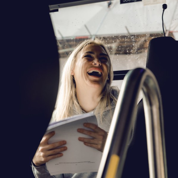 A Hairy Coo driver guide laughing in her coach
