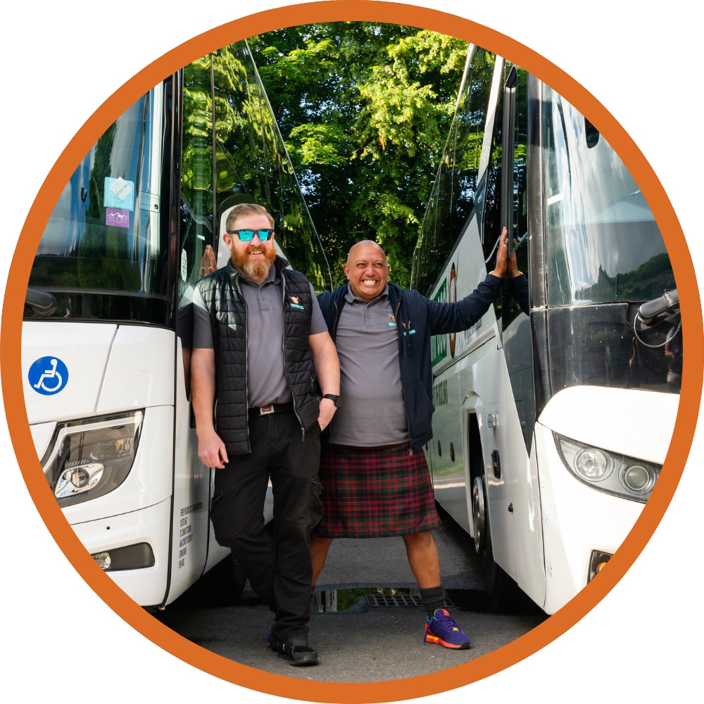 2 Hairy Coo driver tour guides standing beside their Hairy Coo coaches