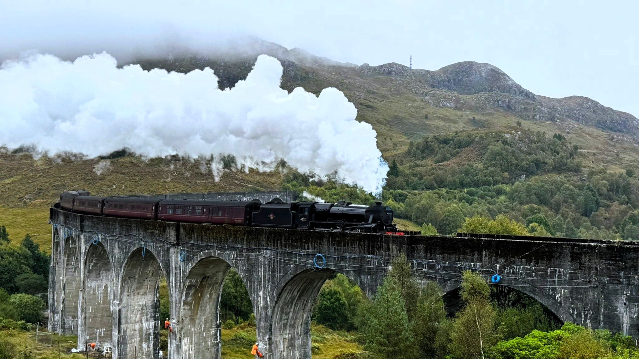 Steam train crossing Glenfinnan Viaduct in Scotland.