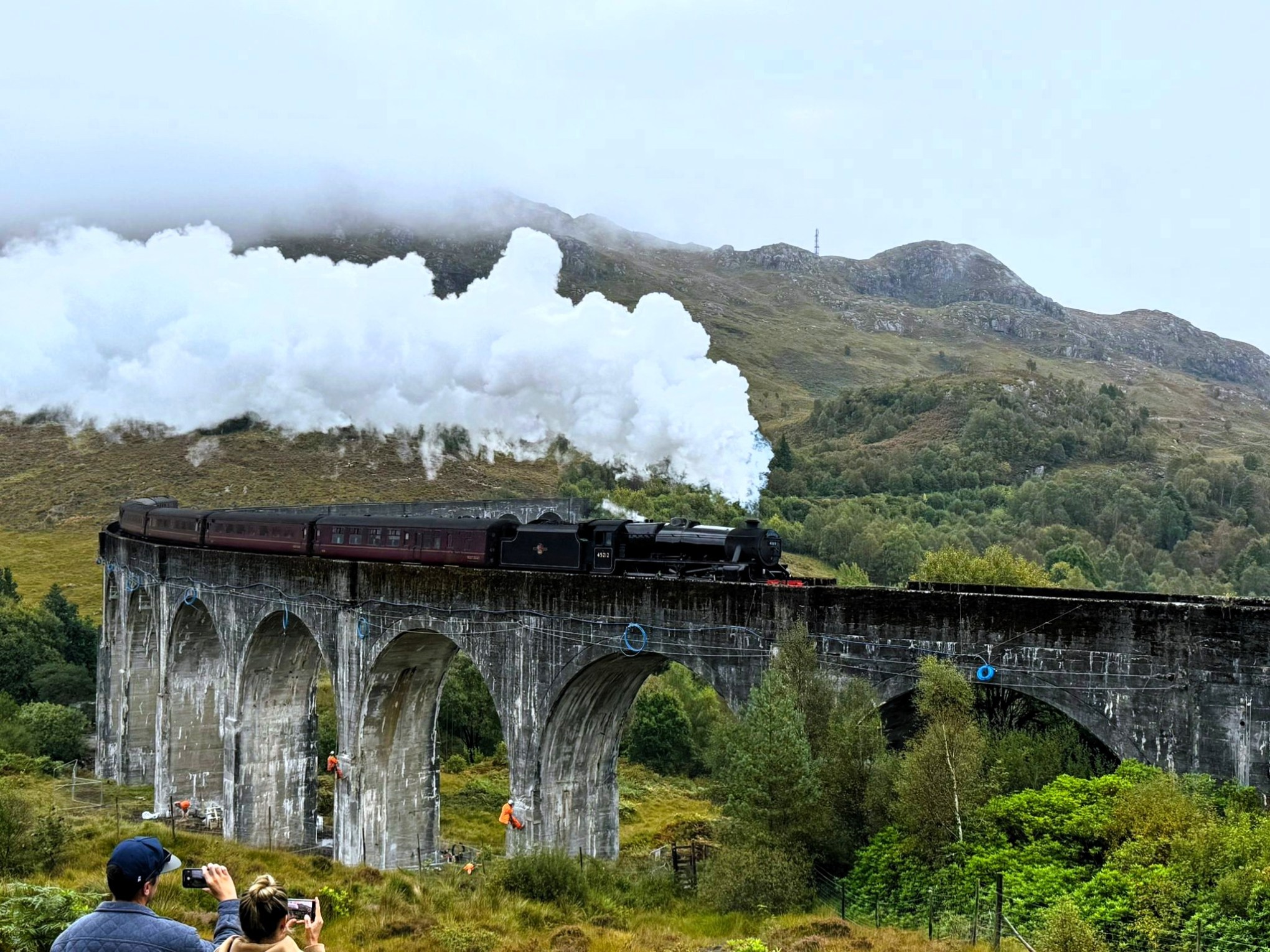 Steam train crossing Glenfinnan Viaduct in Scotland.
